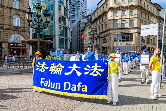 Fahnen- und Transparentträger der European Tian Guo Marching Band mit Falun-Dafa-Transparent in der Frankfurter Innenstadt, 2026