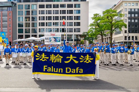 European Tian Guo Marching Band in Aufstellung mit Falun-Dafa-Transparent vor dem Start der Parade in Frankfurt, 2026