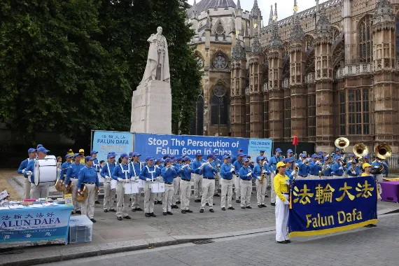European Tian Guo Marching Band vor Westminster Abbey in London mit Transparent gegen die Verfolgung von Falun Gong, 18. Juli 2026