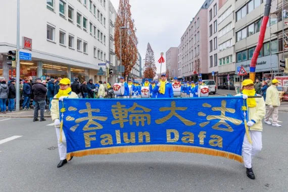 European Tian Guo Marching Band mit dem Falun-Dafa-Banner in einer Einkaufsstraße in Nürnberg, 2023