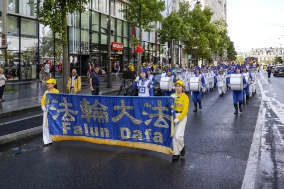 European Tian Guo Marching Band bei Regen auf einem Boulevard in Paris, 2023