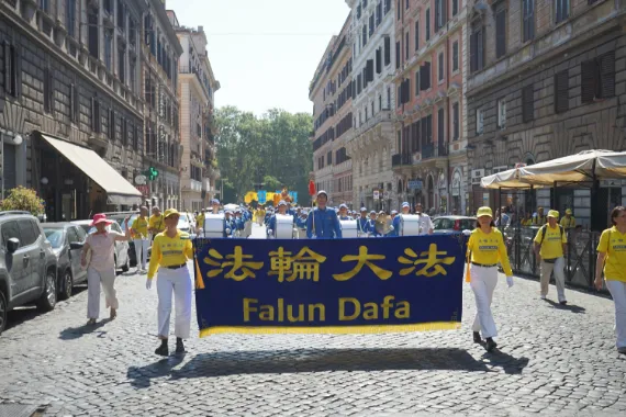 Falun-Dafa-Parade mit der European Tian Guo Marching Band durch eine kopfsteingepflasterte Altstadtstraße in Rom, 2026