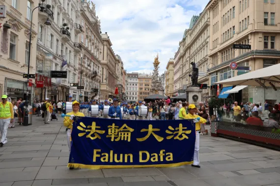 Falun-Dafa-Transparent an der Spitze der European Tian Guo Marching Band auf dem Graben mit der Pestsäule in Wien, 2026