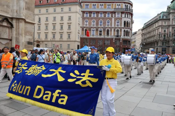 European Tian Guo Marching Band mit Falun-Dafa-Transparent und Trommlern am Stephansdom in Wien, 2026