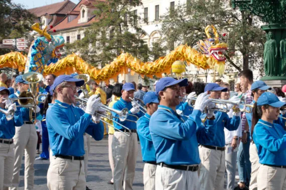 Trompeten und Posaunen der European Tian Guo Marching Band bei einer Parade, im Hintergrund zwei chinesische Drachen des Drachentanzes
