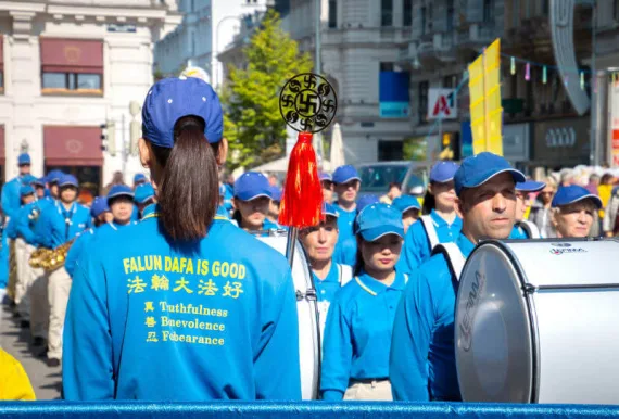 Mitglieder der European Tian Guo Marching Band von hinten, auf den Uniformen steht „Falun Dafa is good“ und „Wahrhaftigkeit, Barmherzigkeit, Nachsicht“